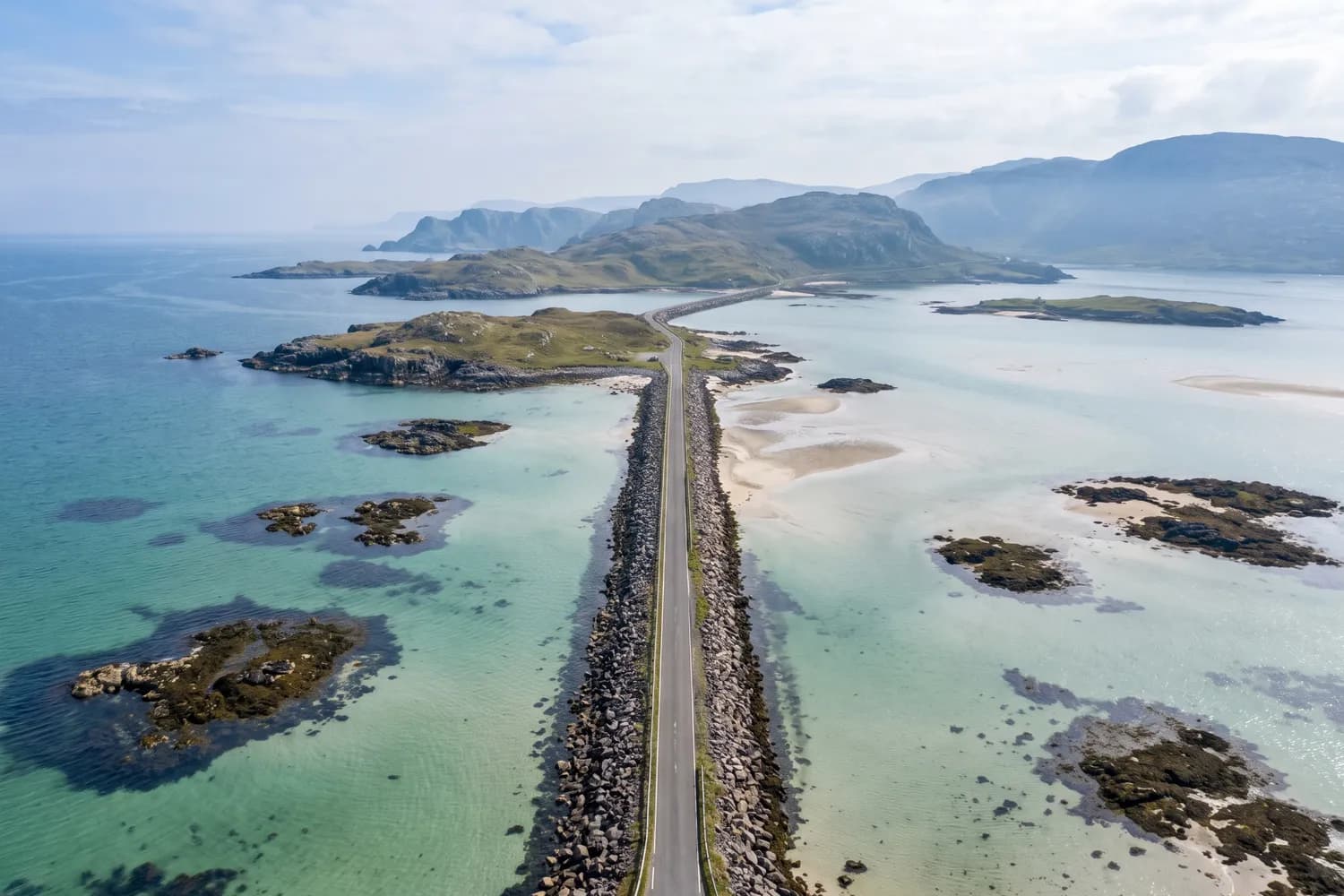 A low causeway carrying a road across shallow tidal water between two islands